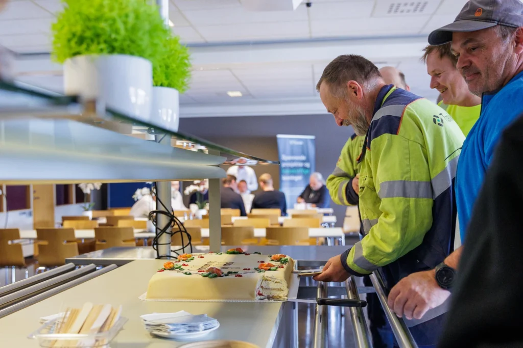 Trosvik-ansatte forsyner seg av kake for å feire ny stor båtbyggerkontrakt