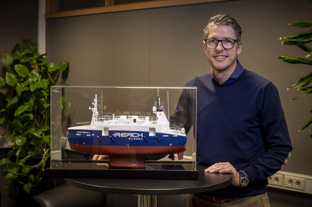 Trosviks prosjektleder Geir Sæther med miniatyr av Reach Remote 1 i glassmonter.