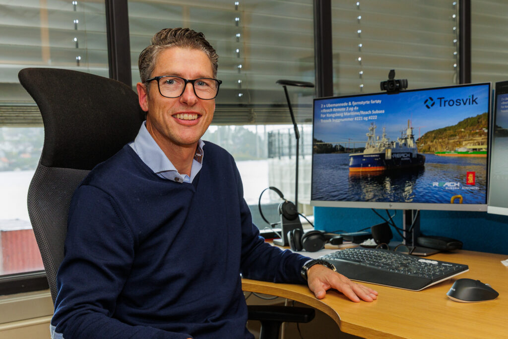 Trosvik Project Manager Geir Sæther at his desk with an image of the Reach Remote vessel on his computer.